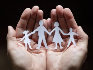 Cutout paper chain family with the protection of cupped hands, concept for security and care